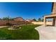 Expansive backyard with well-manicured artificial turf, fire pit, covered patio, and decorative string lights at 2918 E Silverbell Rd, San Tan Valley, AZ 85143