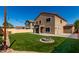 A pristine artificial lawn and fire pit are featured in this spacious backyard with ambient lighting at 2918 E Silverbell Rd, San Tan Valley, AZ 85143