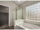 Bathroom featuring a modern glass block window above the tub and a glass enclosed shower at 2918 E Silverbell Rd, San Tan Valley, AZ 85143