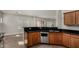 Modern kitchen featuring wood cabinetry, black countertops, and stainless steel appliances at 2918 E Silverbell Rd, San Tan Valley, AZ 85143