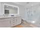 Modern bathroom with a double vanity, an illuminated mirror, and a glass-enclosed shower at 3038 E Stella Ln, Phoenix, AZ 85016