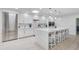 Modern white kitchen featuring a large island with bar seating, stainless steel appliances, and ample cabinet space at 3038 E Stella Ln, Phoenix, AZ 85016