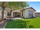 Well-maintained backyard with artificial grass, a covered patio, and a seating area at 3042 N Beverly Pl, Buckeye, AZ 85396