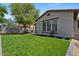Lush backyard with artificial grass, hardscape and a view of the home's exterior at 3042 N Beverly Pl, Buckeye, AZ 85396