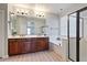 Bright bathroom featuring double sinks, soaking tub, and glass shower at 3042 N Beverly Pl, Buckeye, AZ 85396