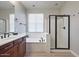 Bright bathroom with wood cabinets, soaking tub, glass enclosed shower, and large vanity at 3042 N Beverly Pl, Buckeye, AZ 85396