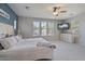 Spacious main bedroom with a large window, ceiling fan, and neutral-colored walls at 3042 N Beverly Pl, Buckeye, AZ 85396