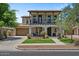 Charming two-story home features a cozy balcony, arched entryway, lush landscaping, and inviting curb appeal at 3042 N Beverly Pl, Buckeye, AZ 85396