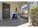 Inviting front porch with a blue cushioned chair, plant, and decorative welcome mat at 3042 N Beverly Pl, Buckeye, AZ 85396