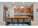 This open concept kitchen showcases wooden cabinetry, a granite countertop island, and seating for four at 3042 N Beverly Pl, Buckeye, AZ 85396