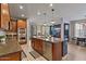 Open-concept kitchen with stainless steel appliances, granite countertops, and an island leading to the dining area at 3042 N Beverly Pl, Buckeye, AZ 85396