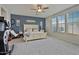 Spacious main bedroom with a large window, neutral carpet, ceiling fan and accent wall at 3042 N Beverly Pl, Buckeye, AZ 85396