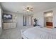 Spacious main bedroom with a large window, neutral carpet, ceiling fan, accent wall and ensuite bathroom at 3042 N Beverly Pl, Buckeye, AZ 85396