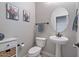 Clean and simple powder room with pedestal sink, toilet, and decorative wall art at 3042 N Beverly Pl, Buckeye, AZ 85396