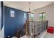 Elegant staircase with dark blue accent wall, decorative chandelier, and iron railing at 3042 N Beverly Pl, Buckeye, AZ 85396