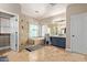 Luxurious bathroom features a soaking tub, glass shower, dual vanities, and travertine tile at 3177 S Sierra St, Gilbert, AZ 85295