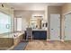 Well lit bathroom featuring a soaking tub, and vanity with tile floor at 3177 S Sierra St, Gilbert, AZ 85295