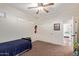 Bedroom with a ceiling fan, carpet flooring, a bed and large closet with sliding doors at 3177 S Sierra St, Gilbert, AZ 85295