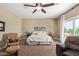 Bright main bedroom with a ceiling fan, bedside tables, soft carpet, and outdoor access at 3177 S Sierra St, Gilbert, AZ 85295