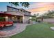 Expansive backyard featuring a covered patio, a built-in grill, artificial turf, and multiple seating areas for outdoor living at 32359 N 129Th Dr, Peoria, AZ 85383