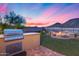 Outdoor cooking area and fire pit surrounded by lush landscaping at 32359 N 129Th Dr, Peoria, AZ 85383