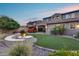 Expansive backyard featuring a fire pit, artificial turf, desert landscaping, a covered patio, and an outdoor kitchen at 32359 N 129Th Dr, Peoria, AZ 85383