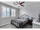 Cozy bedroom with ceiling fan, grey walls, and natural light from shuttered windows at 32359 N 129Th Dr, Peoria, AZ 85383