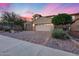 Charming exterior elevation showcasing a well-maintained yard, a brick driveway, mature trees and a two-car garage at 32359 N 129Th Dr, Peoria, AZ 85383