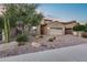 Beautiful exterior elevation showcasing a well-maintained yard, desert landscaping, and a two-car garage at 32359 N 129Th Dr, Peoria, AZ 85383