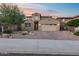 Beautiful exterior elevation showcasing a well-maintained yard, a brick driveway, mature trees and a two-car garage at 32359 N 129Th Dr, Peoria, AZ 85383