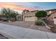 Charming exterior elevation showcasing a well-maintained yard, a brick driveway, mature trees and a two-car garage at 32359 N 129Th Dr, Peoria, AZ 85383