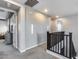 Bright upstairs hallway featuring gray walls, carpet flooring, and black railing along the stairway at 32359 N 129Th Dr, Peoria, AZ 85383