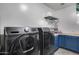 Laundry room with modern washer and dryer, blue cabinets and shelf for storage at 32359 N 129Th Dr, Peoria, AZ 85383