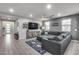 Open-concept living room showcasing a media console and a large sectional sofa at 32359 N 129Th Dr, Peoria, AZ 85383