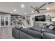 Large living room showcasing the stairs, wood accent wall, sectional sofa, and media console at 32359 N 129Th Dr, Peoria, AZ 85383