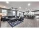 Open-concept living room with a large sofa, fan and a view into the kitchen area at 32359 N 129Th Dr, Peoria, AZ 85383