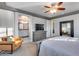 Relaxing main bedroom featuring a ceiling fan and view into the ensuite bathroom at 32359 N 129Th Dr, Peoria, AZ 85383