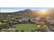 Scenic aerial view of a community with lush green spaces and mountain backdrop at sunset at 3765 N Denny Way, Buckeye, AZ 85396