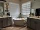 Stylish bathroom with a soaking tub, double sinks, and ample natural light at 3765 N Denny Way, Buckeye, AZ 85396