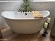 Bright bathroom featuring a soaking tub, matte fixtures, decor, white subway tile, and wood-look floors at 3765 N Denny Way, Buckeye, AZ 85396