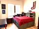 Inviting bedroom featuring a red comforter, built-in storage, and decor for a teen at 3765 N Denny Way, Buckeye, AZ 85396