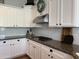 Close-up showcasing kitchen features: white cabinetry, granite countertops, and a stainless steel range hood at 3765 N Denny Way, Buckeye, AZ 85396