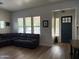 Bright and airy living room featuring a comfortable leather sectional and large windows with bright natural light at 3765 N Denny Way, Buckeye, AZ 85396