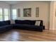 Inviting living room with a large sectional sofa, decorative art, and hardwood floors at 3765 N Denny Way, Buckeye, AZ 85396