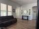 Spacious living room featuring wood-look floors and a large leather sectional, perfect for entertaining at 3765 N Denny Way, Buckeye, AZ 85396