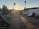 Backyard in disrepair with debris, a fence and palm trees in the distance at 3946 W Holly St, Phoenix, AZ 85009