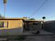 View of the backyard with a detached garage, utility lines, and a palm tree in the distance at 3946 W Holly St, Phoenix, AZ 85009