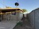 View of the backyard with a detached garage, a satellite dish, and a block wall at 3946 W Holly St, Phoenix, AZ 85009