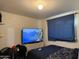 A cozy bedroom featuring a comfy bed, TV, and curtains, creating a relaxing ambiance at 3946 W Holly St, Phoenix, AZ 85009