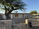 Exterior view of a cozy single story home with a big tree and a small patio area and low fence at 3946 W Holly St, Phoenix, AZ 85009